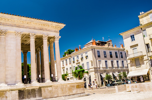 Nimes, France - July 15, 2014: The Grecian columns of La Maison Carree at the Place de la Maison Carree at Nimes in the south of France. Built just before the time of Christ, it is one of the best preserved Roman temples in Europe, with its classic design being the inspiration for Thomas Jefferson's Virginia State Capitol.