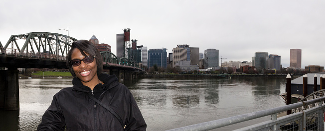close up of a young woman in front of Portland, Oregon's waterfront