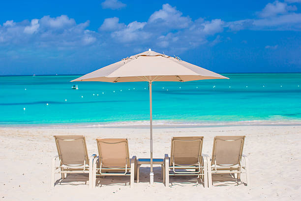 istock White umbrellas and sunbeds at tropical beach 514377275