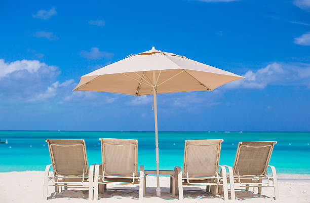 istock White umbrellas and sunbeds at tropical beach 514377279