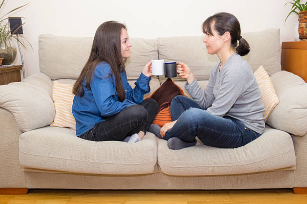 istock Mother and daughter sitting on a couch 514378060