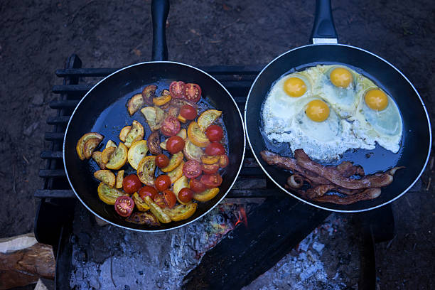 Breakfast on the Campfire Cooking eggs and bacon on a campfire. sandbanks ontario stock pictures, royalty-free photos & images