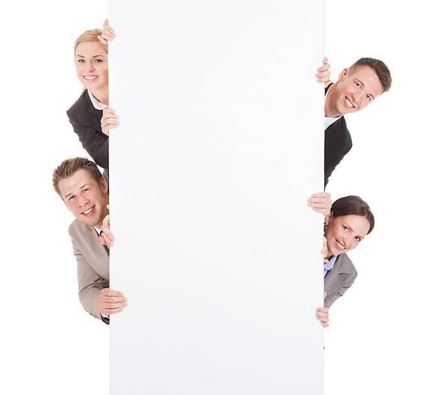 istock Business People Looking From Behind The Blank Billboard 514380321