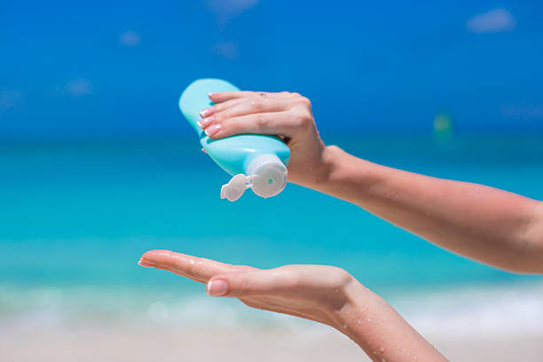 istock Woman hands putting sunscreen from a suncream bottle 514382241