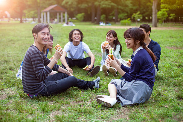 heureux groupe d'amis japonais repas dans le parc tokyo - coffee to go flash photos et images de collection
