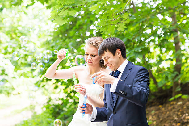 istock beautiful wedding couple blowing bubbles 514384500