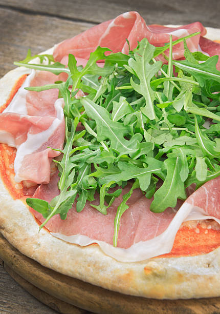 istock Italian pizza with ham and fresh rocket salad 514385116