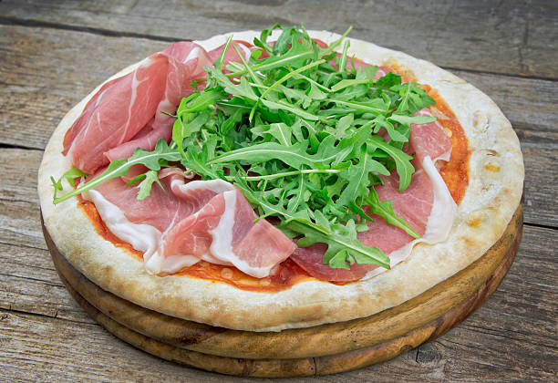 istock Italian pizza with ham and fresh rocket salad 514385696