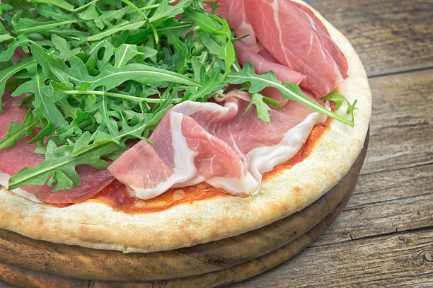 istock Italian pizza with ham and fresh rocket salad 514387046