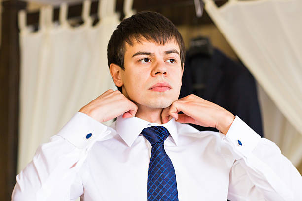 istock Businessman putting on a necktie 514387684