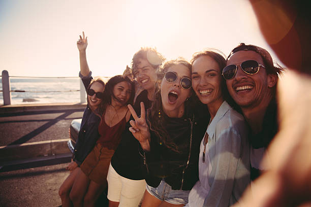 hipster adolescente com amigos fazendo uma selfie na praia ao ar livre - summer vacations adolescence teenager - fotografias e filmes do acervo