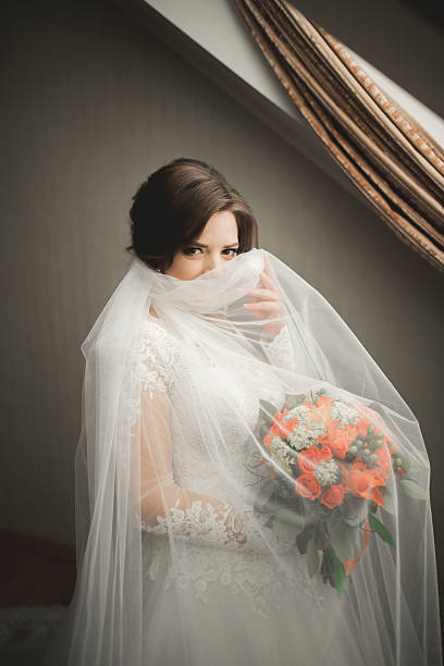 istock Luxury bride in white dress posing while preparing for the 514389740
