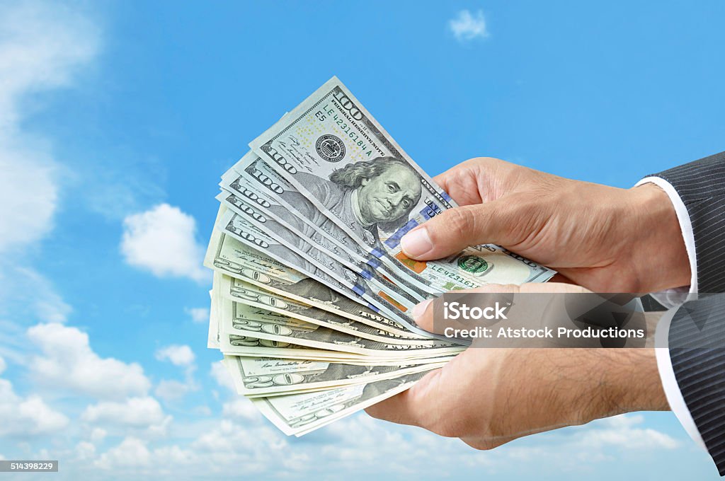 Hands holding money -  United States dollar (USD) bills American One Hundred Dollar Bill Stock Photo