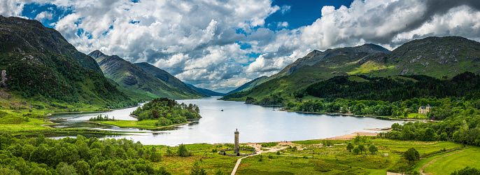 Big Highland skies over the rocky mountain peaks and green glen of Loch Shiel framing the historic Glenfinnan Monument to Bonnie Prince Charlie, Lochaber, Scotland. ProPhoto RGB profile for maximum color fidelity and gamut.