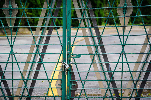 Locked green gate on an access road