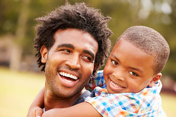istock Father Giving Son Piggyback Ride In Park 514403193