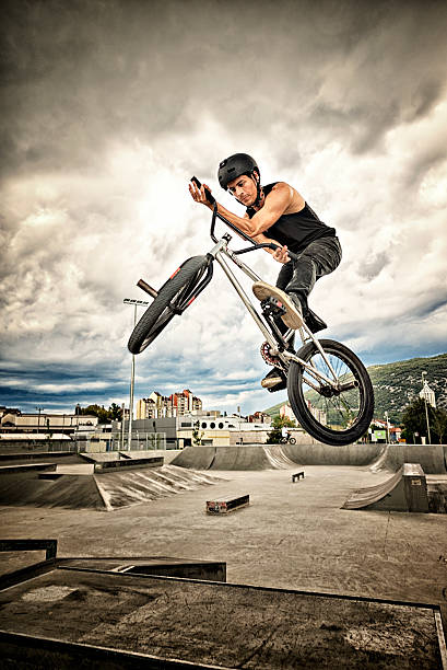BMX biker BMX biker performing a stunt in ramp park. bicycle stunts stock pictures, royalty-free photos & images