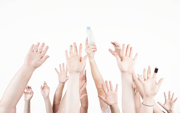istock Group of raised hands, one holding a bottle of water 514406330