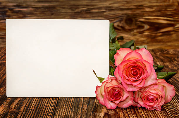 istock Three roses with blank greeting card on a wooden background 514407110
