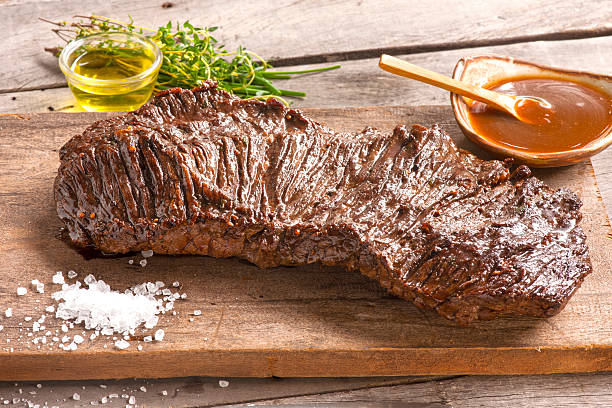 Brazilian barbecue meat Delicious flank Steak placed on a cutting board, prepared in the Brazilian way, this side cut of beef is locally known as Fraldinha. flank steak stock pictures, royalty-free photos & images