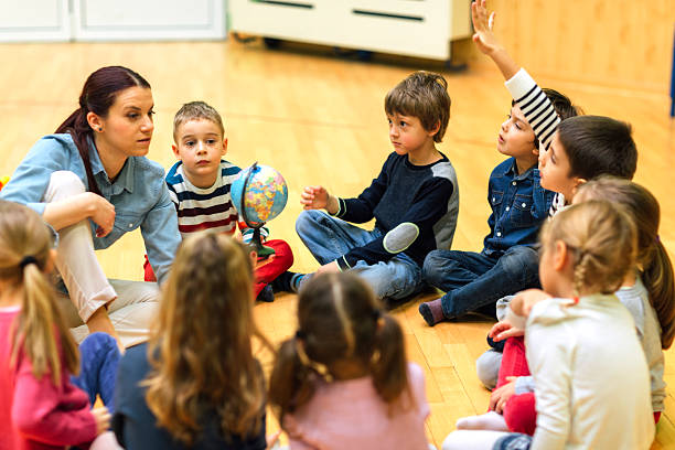 istock Preschool teacher and children in classroom 514409812