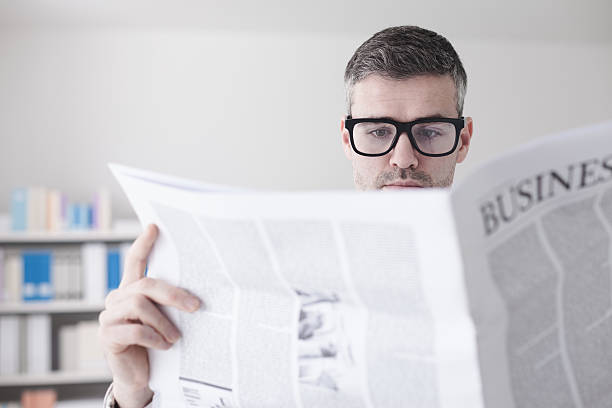 istock Confident businessman reading a newspaper 514411494