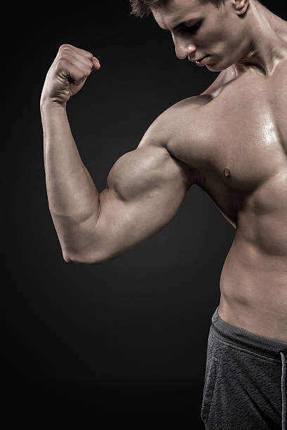 istock Fitness man showing his triceps, biceps muscles on black background 514413042