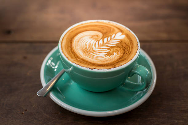 istock hot cappuccino with latte art on wood background 514414768