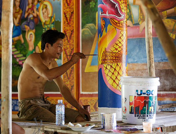 Cambodian young artist paints a temple near Kampot. Kampot, Cambodia - April 26, 2014: Cambodian young artist paints a temple near Kampot. kampot stock pictures, royalty-free photos & images