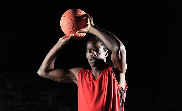 istock African player throwing basketball- black bakcground 514418714