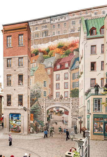 Old Quebec City, Canada - October 6, 2013:  Tourists look at the gigantic Trompe l'oeil mural, Fresque des Québécois on Côte de la Montagne, in Old Quebec City.  The mural is an old city scene with historic figures, writers and artists.
