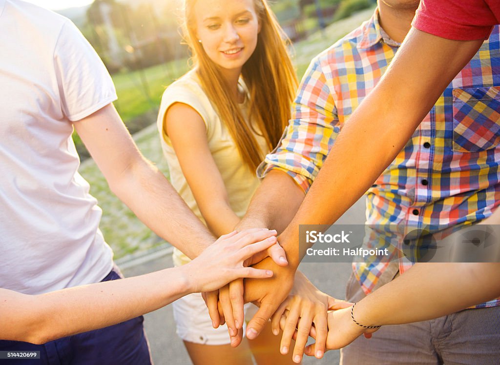 Friends with hands in stack Group of young people with hands in stack Achievement Stock Photo