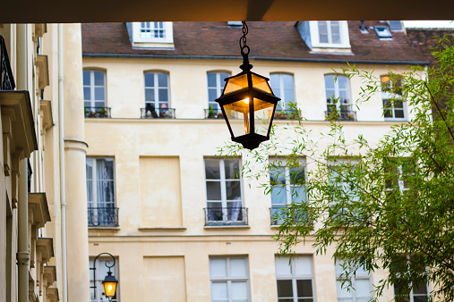Lit for evening lantern hanging in one of the parisian front yards, Paris, France
