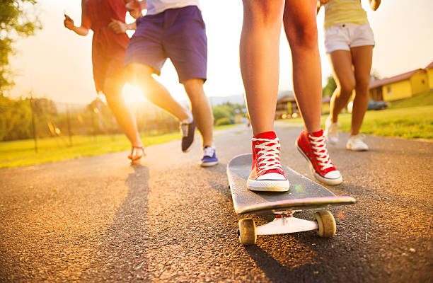 Closeup of legs and sneakers of young people on skateboard