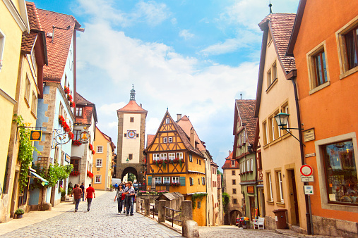 Rothenburg ob der Tauber, Germany - July 26th 2010: Tourist sightseeing at Plonlein (little square) with Sieber Tower and Kobolzeller Tower. Plonlein is one of the most famous place in Rothenburg ober der Tauber.