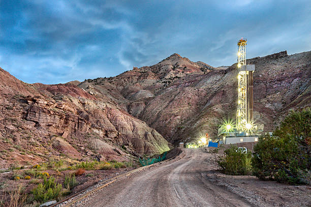 Drilling Fracking Rig at Dusk Evening shot of a Fracking Drill Rig using fracking technology under a moody skyFracking Oil Well is conducting a fracking procedure to release trapped crude oil and natural gas to be refined and used as energy north dakota stock pictures, royalty-free photos & images