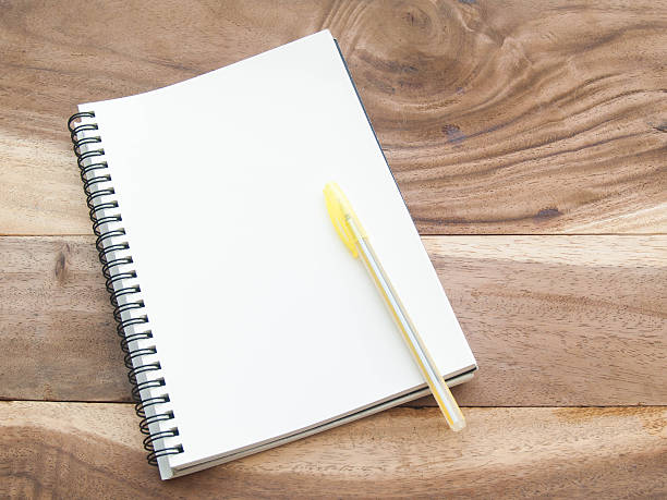 istock white note with yellw pen on wood table 514424380