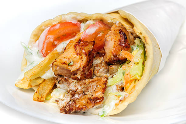 greek gyros greek gyros stuffed with meat, salad, onion, tomato and potato shawarma stock pictures, royalty-free photos & images