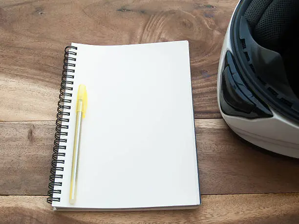 Photo of white helmet and white book on old wood table