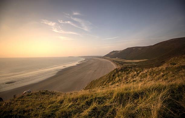 Welsh beach at sunset  taken from the surrounding cliffs view of a beach at sunset taken from the surrounding cliffs gower peninsular stock pictures, royalty-free photos & images
