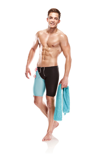 Young attractive caucasian man swimmer with goggles and towel isolated over white background