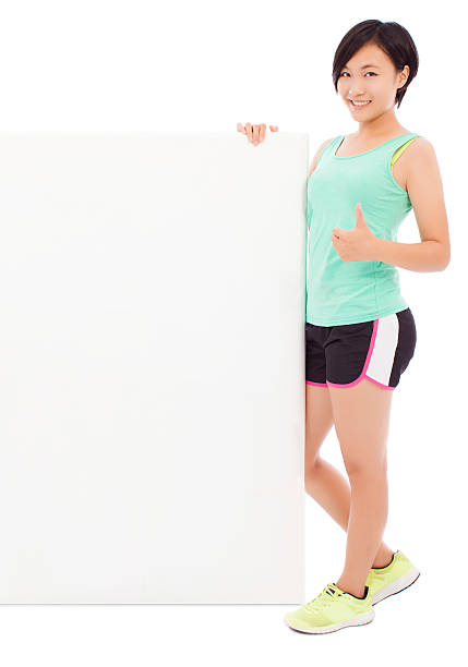 istock young female athletes holding a empty board and thumb up. 514438001