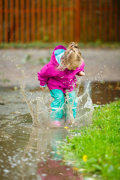 istock Happy little girl plays in a puddle 514454083