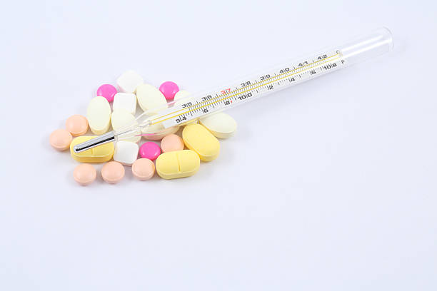 Tablets pills heap color mix therapy drugs and thermometer stock photo