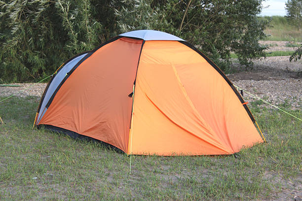 istock Orange tent at a picnic in the forest with grass 514456581