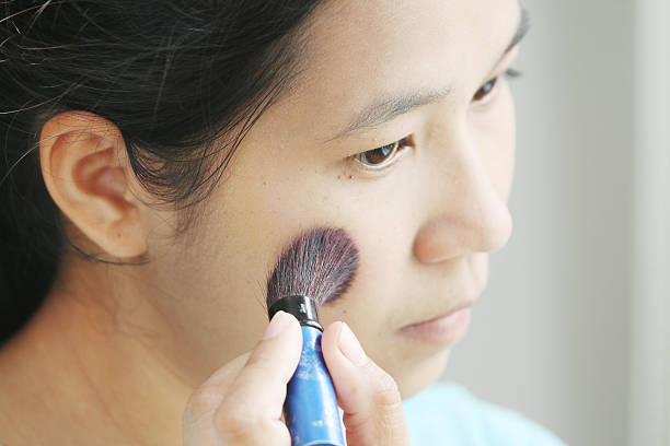 istock woman applying make up by rouge. 514456627