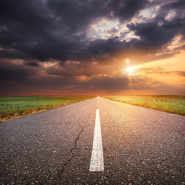istock Driving on an empty asphalt road at sunset 514456995