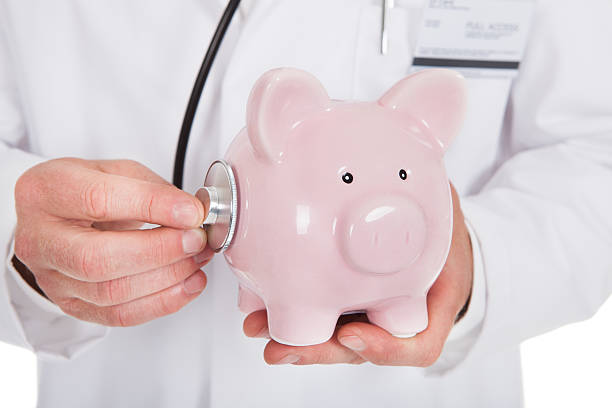 istock Doctor Examining Piggybank With Stethoscope 514457693