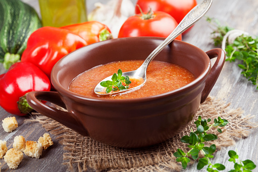 Delicious gazpacho on wooden table and fresh vegetablesDelicious gazpacho on wooden table and fresh vegetables