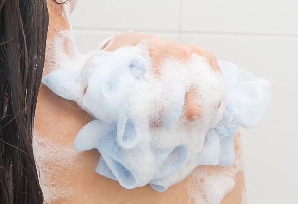 istock Woman take a shower and clean her back with puff 514459637